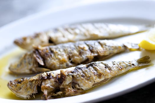 close up of plate of grilled sardines