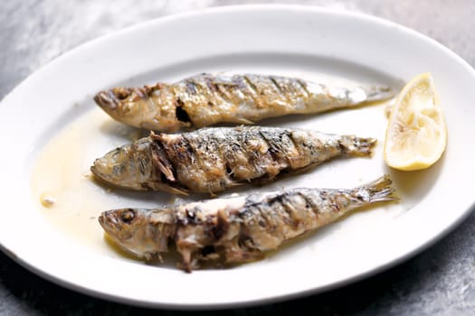close up of plate of grilled sardines
