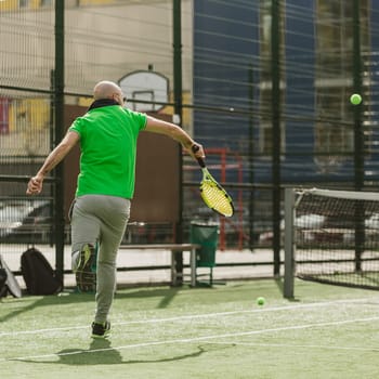 young man play tennis outdoor on tennis field at early morning