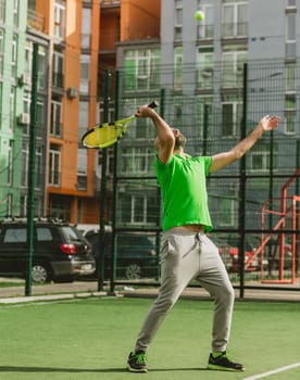 young man play tennis outdoor on tennis field at early morning
