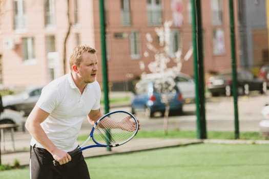young man play tennis outdoor on tennis field at early morning