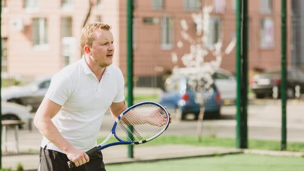young man play tennis outdoor on tennis field at early morning