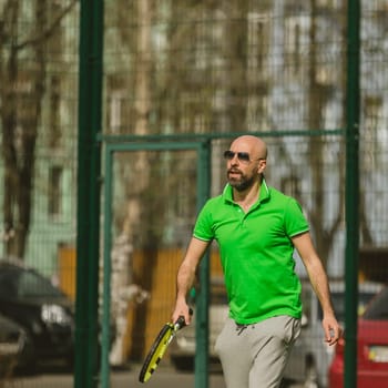young man play tennis outdoor on tennis field at early morning