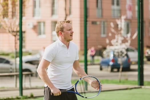 young man play tennis outdoor on tennis field at early morning