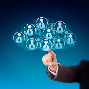 Forearm of a business person is reaching out to click on human resources icons in the cloud. Many knowledge worker buttons do shape this cloud computing symbol. Technology metaphor. Blue background.