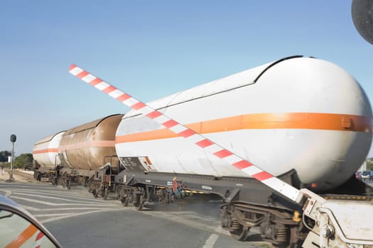 Merchandise wagon with oil tanks crossing on the road