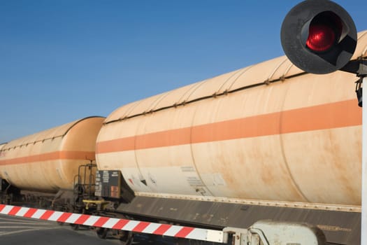 Merchandise wagon with oil tanks crossing on the road