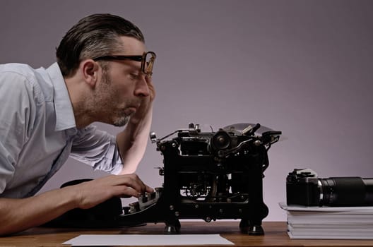 Editor with an old typewriter and retro camera on a wooden office table