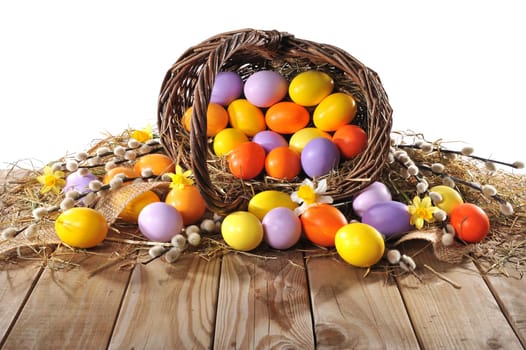Easter basket with Easter eggs,daffodils and palm kittens on old weathered wooden boards