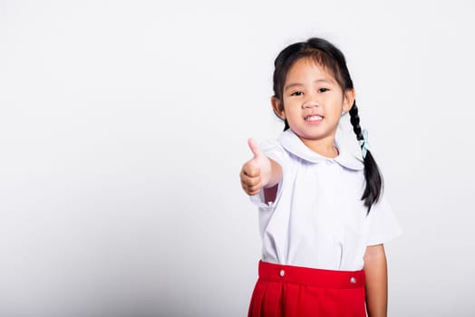 Asian adorable toddler smiling happy wear student thai uniform red skirt show thumb up finger in studio shot isolated on white background, Portrait little children girl preschool, Kid Back to school