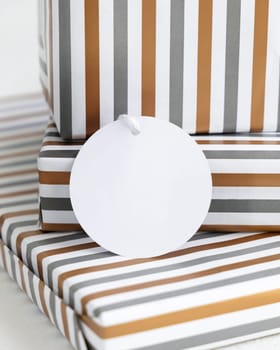 Presents with blank round gift tag close up. Gift boxes wrapped in Striped geometric paper. Christmas, New Year, Birthday, Anniversary label mockup