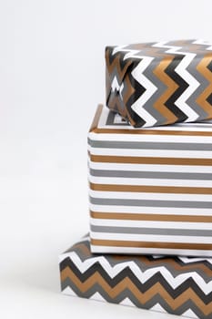 Presents Wrapped in striped and chevron geometric paper on white table close up. Christmas, New Year, Birthday, Anniversary concept