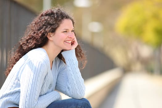 Happy woman contemplating and relaxing in a park