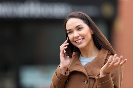 Happy woman in winter making a phone call