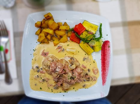 Fried potatoes and schnitzel with sauce