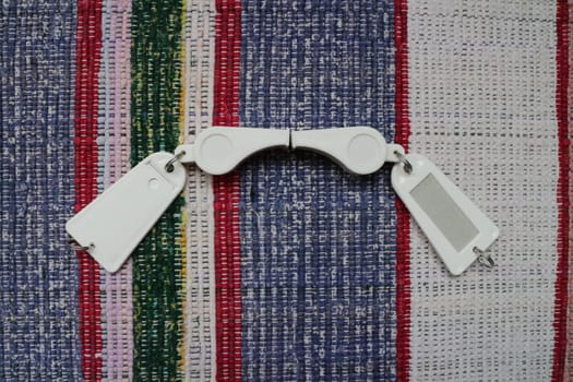 two white sports whistle, signal, fan, with a tag