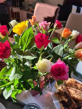 A bouquet of roses in a vase on a bedside table