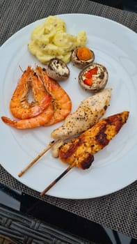 Grilled meat on wooden skewers on plate. Top view, lying flat