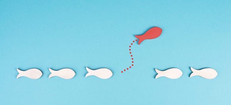 One red fish takes a different direction, leader of the group, leadership and teamwork concept, be a winner, success and start up in business, follow a new idea, jump to freedom