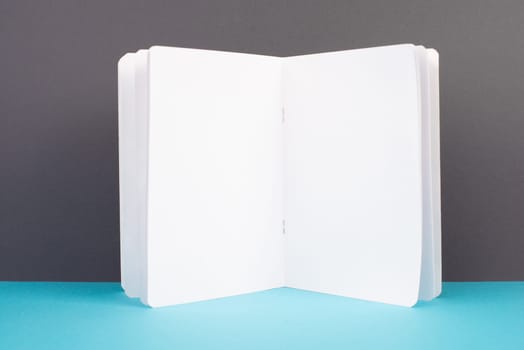 Open white book page, school and education concept, copy space for text, blank paper, gray and blue background