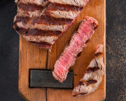 Grilled beef fillet steaks on dark table close up top view. Cooked Portioned filet mignon. Concept of summer food, meat eaters.