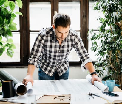 Young man working on architectural project. Modern office concept.
