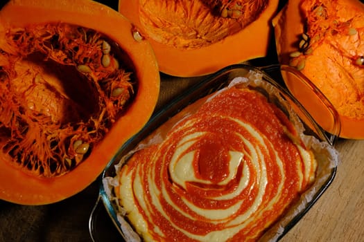 Homemade pumpkin pie cheesecake with piece of pumpkin sliced on parts. Orange dessert. vertical image. top view.