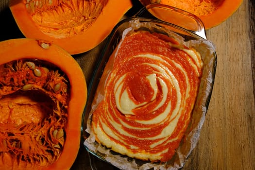 Homemade pumpkin pie cheesecake with piece of pumpkin. Orange dessert. vertical image. top view. place for text wooden background