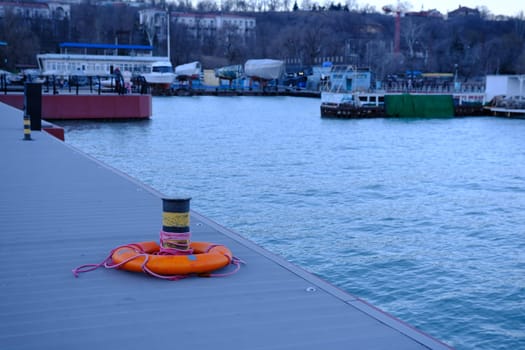 Lifebuoy ring on berth near the bollard with sea view of Marina Mariupol, Ukraine outdoors