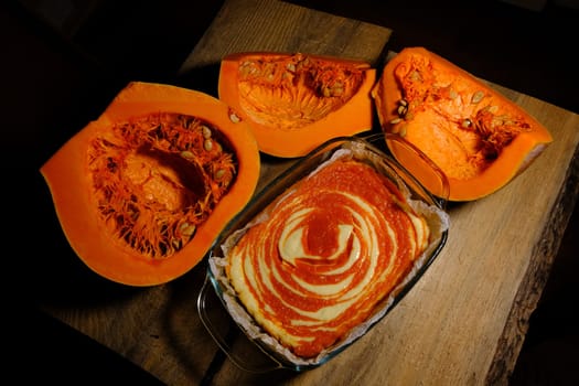 Homemade pumpkin pie cheesecake with piece of pumpkin. Orange dessert. vertical image. top view. wooden background.