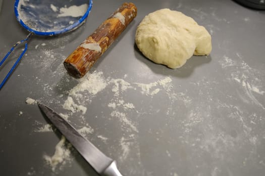 pizza dough with flour rolling pin and knife