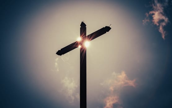 Wooden cross with sun, sky and clouds in background.