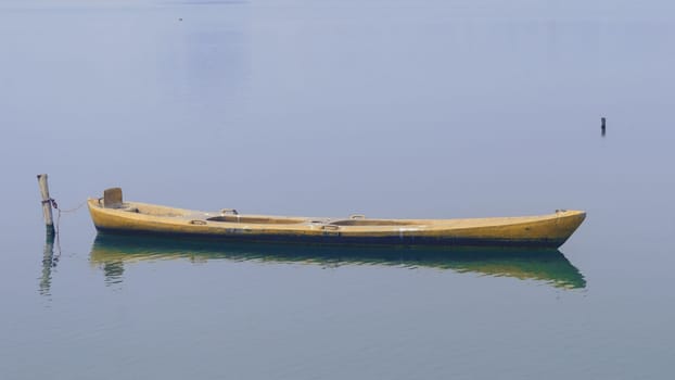 Close up view on beautiful wooden flat rowing boat moored on lake