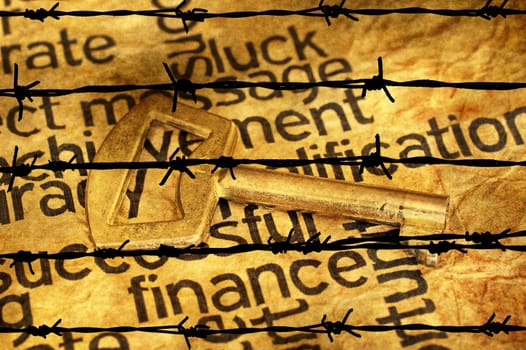 Finance and golden key against barbwire