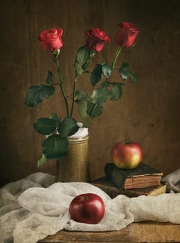 Still life with red roses and apples.