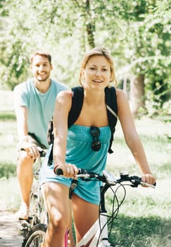 Young man and woman having a bike ride in nature. Retro filter.