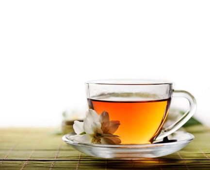 Tea cup with jasmine flowers and white copyspace