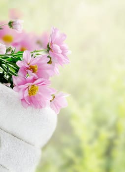 White clean towels and fresh flowers with green natural background