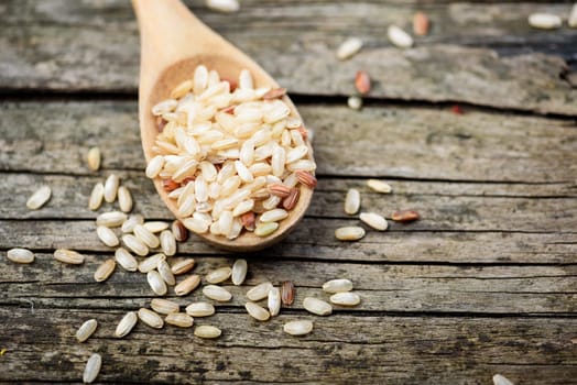 Rice in wooden spoon on rustic table