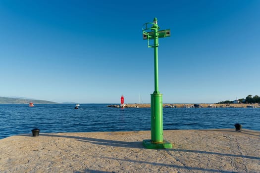 green Lighthouse at a pier in the port of Krk on the Adriatic Sea in Croatia
