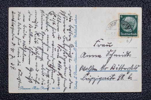 Potsdam, Germany - MAY 06, 2022. A old postcards from 1939 with stamp showing the portrait of the German Reich President Paul von Hindenburg, Germany, Third Reich. Black background.