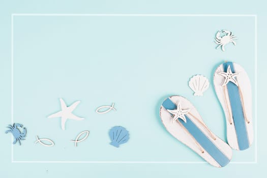 Blue colored summer and holiday background, flip flops, sea stars and crabs with copy space, travel and tourism concept