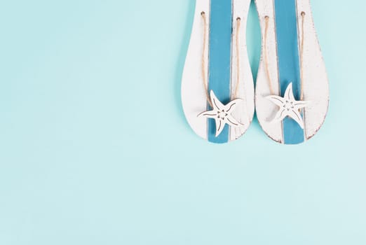 Blue colored summer and vacation background, slippers with sea stars, copy space for text, holiday and tourism concept