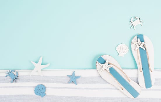 Blue colored summer and holiday background, flip flops, sea stars and crabs with copy space, travel and tourism concept