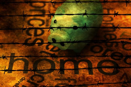 Piggy bank and home text against barbwire