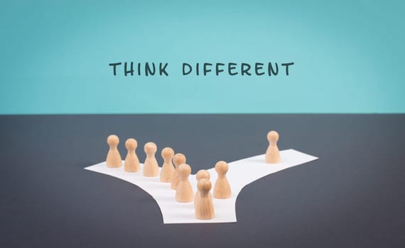 Think different stands on the blue background, one nonconformist is standing out from the crowd, creative and visionary concept, mass follows the group