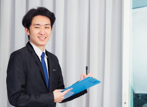 Work from home, Asian young businessman video conference call or facetime he smiling write notebook information at the home office