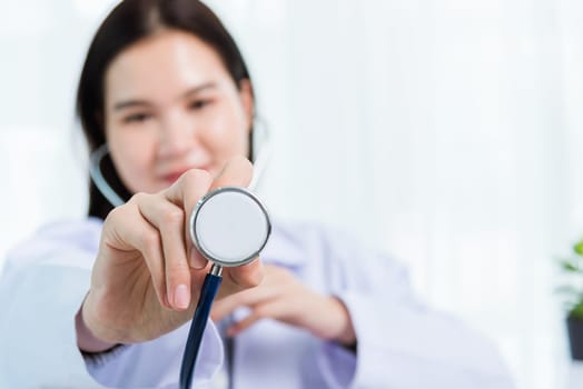 Portrait Asian confident female doctor working personal laptop computer at the hospital office. Thai woman medical expertise staff smiling hand to hold show stethoscope on desk space front computer