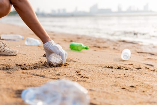 Volunteer woman picking plastic bottle into trash plastic bag black for cleaning the beach, female clean up garbage, Ecology concept and World Environment Day, Save earth concept