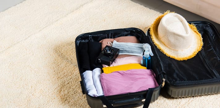 Open suitcase with traveler belongings clothes and accessories of things ready packing to be taken on summer holiday, Travel vacation luggage preparations concept, top view
